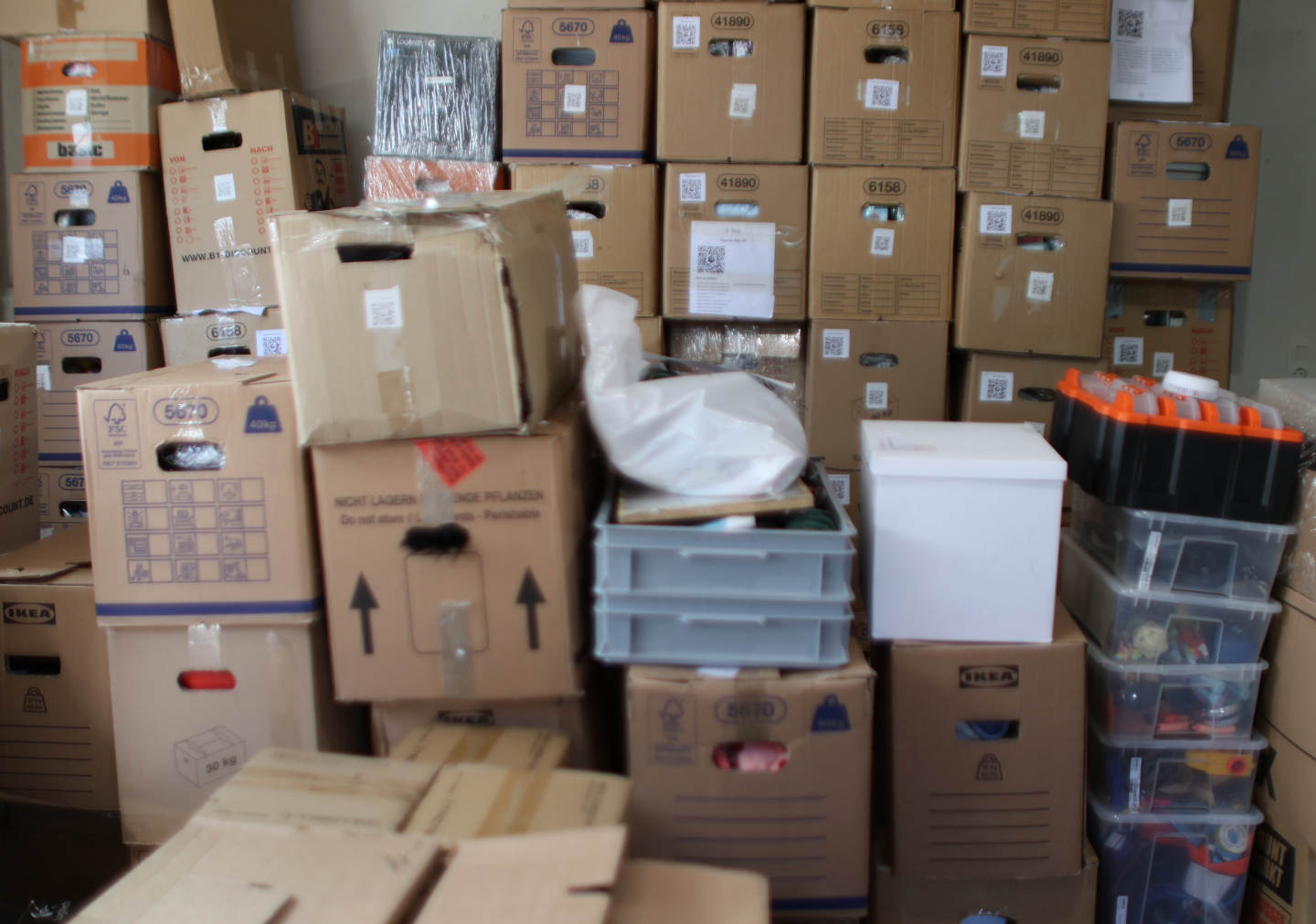 Wide basement storage area with stacked boxes and shelving